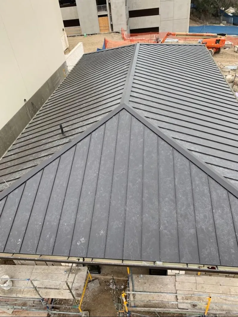 Commercial metal roof construction with crane equipment in Pittsford